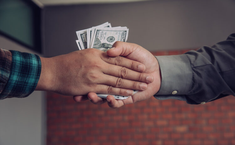 Businessmen handshake with money in hands corruption concept