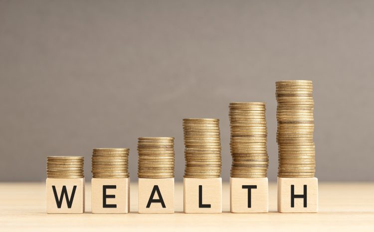 Wealth word in wooden blocks with coins stacked in increasing stacks Wealth increasing concept Copy space