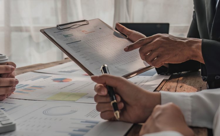 Business People Meeting using laptop computer,calculator,notebook,stock market chart paper for analysis Plans to improve quality next month Conference Discussion Corporate Concept